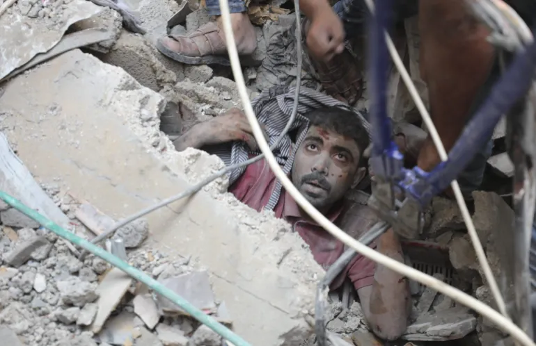 A survivor of Israeli heavy bombardments rescued/AP